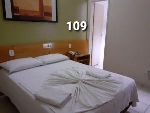 瓦拉达里斯州长市HOTEL PRINCIPE的卧室配有一张白色的床,墙上有数字