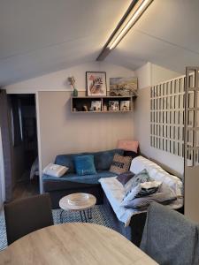 圣库隆Mobilhome tout confort, proche Saint-Malo, à 50 m de la plage et du GR34的客厅配有蓝色的沙发和桌子