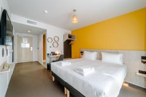 布鲁瓦Beelodge Hotel Blois Centre的卧室配有一张白色大床和黄色墙壁