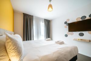 布鲁瓦Beelodge Hotel Blois Centre的卧室配有白色的床和窗户。