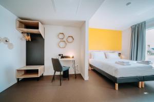布鲁瓦Beelodge Hotel Blois Centre的一间卧室配有一张床、一张桌子和一把椅子