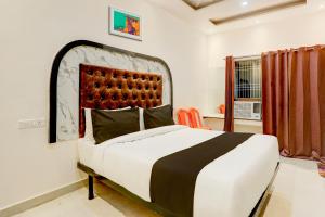 瓦拉纳西Super OYO Flagship SHIVA VALLEY HOTEL的一间卧室设有一张大床和一个窗户。