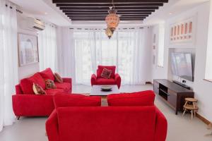 KikambalaThe Casa Sultan的客厅配有红色沙发和电视