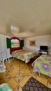亚美尼亚La Mía Hospedaje的一间设有两张床和一张桌子的房间