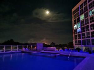 普拉亚科罗纳多Apartamento de playa con vista al mar en coronado的夜间与月亮相映成像的建筑景观