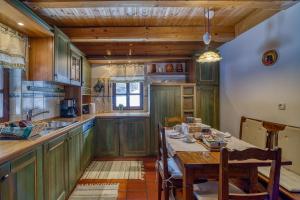 波希基斯卡贝拉Chalet Kupljenik Near Bled Lake的厨房配有绿色橱柜和桌椅