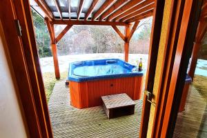 Dol pri HrastnikuForester's Hut With Whirlpool & Sauna - Happy Rentals的甲板上的热水浴缸,配有桌子