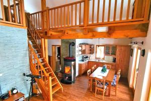 Dol pri HrastnikuForester's Hut With Whirlpool & Sauna - Happy Rentals的一间厨房和带螺旋楼梯的用餐室,位于一栋房子内