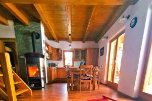 Dol pri HrastnikuForester's Hut With Whirlpool & Sauna - Happy Rentals的厨房配有桌子和燃木炉。