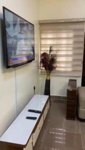 阿布贾LA VIVA AIRBNB的客厅配有白色桌子和平面电视。