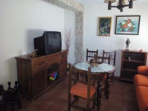 卡索拉Casa Hortensia的客厅配有电视和带桌子的桌子。