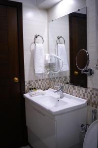拉合尔Faletti’s Grand MM Alam Road的浴室设有白色水槽和镜子