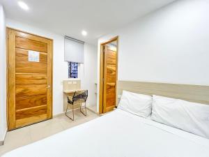 蒙特里亚Stanza Hotel Monteria的一间卧室配有一张床和一扇木门