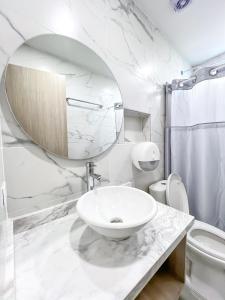 蒙特里亚Stanza Hotel Monteria的白色的浴室设有水槽和镜子