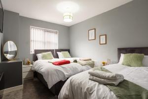 罗瑟勒姆Lovely Getaway Apartment: Two-Bedroom in Rotherham的一间卧室配有两张床和镜子