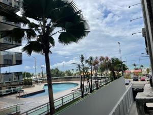 福塔莱萨Apartamento BEIRA MAR的棕榈树和阳台的游泳池