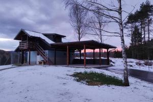 TrebčePočitniška hiška v gozdnem raju的雪中带屋顶的建筑