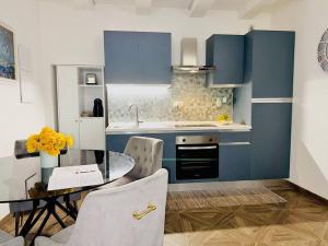 威尼斯Gloria luxury home的厨房配有蓝色橱柜和桌椅