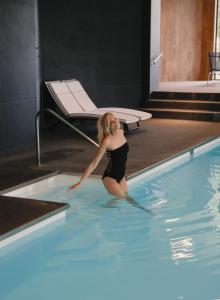 奥维法特德斯法尼斯多美酒店的身着泳衣的妇女站在游泳池里