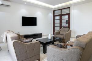 NgorResidence Mandela Almadies Dakar, Senegal, Ngor Almadies的客厅配有两张沙发和一台电视机