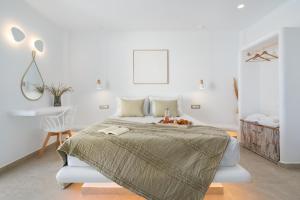 佩里沃罗Electra Suites & Spa的白色卧室配有床和椅子