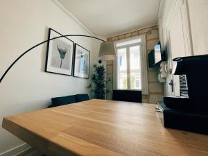 波尔多Respire Bordeaux的一间带木桌和窗户的用餐室
