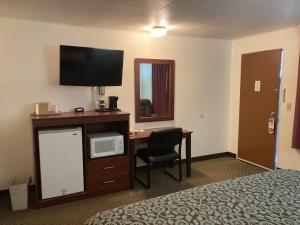 温泉城希尔斯旅馆的酒店客房设有一张床和一张带电视的书桌。