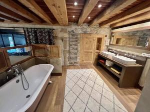 Héry-sur-AlbyFrench Farmhouse between Lake & Mountain的大型浴室设有两个盥洗盆和浴缸。