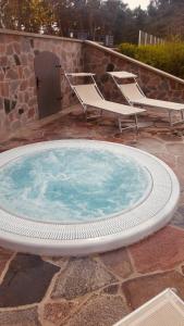 韦巴Zamek Łeba Resort & Spa的热水浴池配有2把椅子和桌子