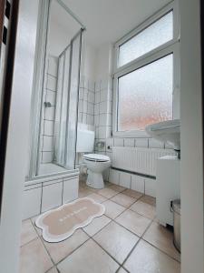 诺德奈Dions Rooms的一间带卫生间的浴室、一个窗户和地毯