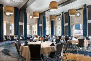 西雅图西雅图市中心万怡先锋广场酒店的一间会议室,配有桌椅和窗户