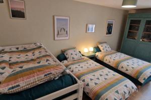 阿普瓦尼Le Grand Bourgeois的一间卧室设有两张床和一扇绿门