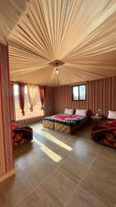 瓦迪拉姆Wadi Rum Magic Camp的大房间设有两张床和天花板