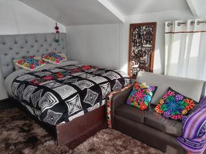 普诺CHUYPAS DEL TITICACA的一间卧室配有一张床和一张沙发