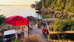 莱迪史密斯SeaLaVie Rare Peaceful & Hidden Gem Shore House的水边木板路上的红伞
