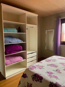 格拉玛多Família Cavalli的一间卧室配有一张带粉色和紫色枕头的床