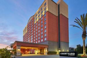 洛杉矶Courtyard by Marriott Los Angeles Westside的一座建筑前有棕榈树的酒店