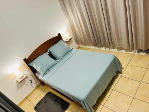 MatouryBlue Home2 T3 meublé à Matoury pour 1 à 6 voyageurs.的一间卧室配有一张带蓝色枕头的床。