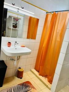 MatouryBlue Home2 T3 meublé à Matoury pour 1 à 6 voyageurs.的浴室设有橙色淋浴帘和水槽