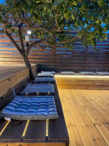 罗德镇Casa de Manu的木甲板上设有绿树和蓝色的睡眠垫