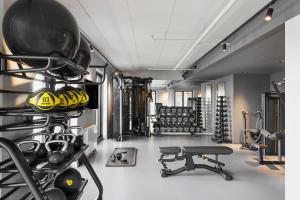 哥本哈根Fairfield by Marriott Copenhagen Nordhavn的一间健身房,里面装有一排头盔和重量