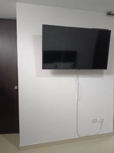 亚美尼亚Habitación en apartamento familiar的挂在白色墙壁上的平面电视