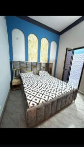 瓦加杜古Sanyiri meublée的一间卧室配有一张带蓝色墙壁的大床