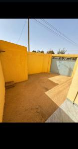 瓦加杜古Sanyiri meublée的一个空房间,有黄色的墙壁和斜坡