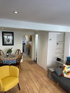 布莱顿霍夫North Laine Sunny Cottage的客厅和配有桌子及黄色椅子的用餐室