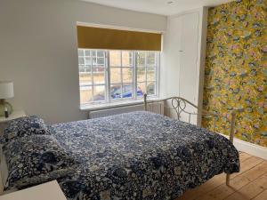 布莱顿霍夫North Laine Sunny Cottage的一间卧室配有一张带蓝色毯子的床和窗户。