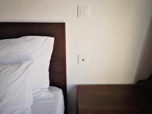 莫尼兹港欧罗莫尼斯酒店的一张铺有白色床单的床和木制床头板