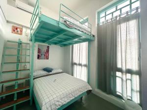 马六甲Melaka jonker street kids friendly guesthouse Malacca的一间卧室配有一张双层床和梯子