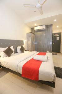 卡延Hotel Leesha Residency的一间卧室配有一张大床,铺有红白毯子