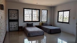 素叻U Zone Hostel & Cafe的一间卧室设有两张床和两个窗户。